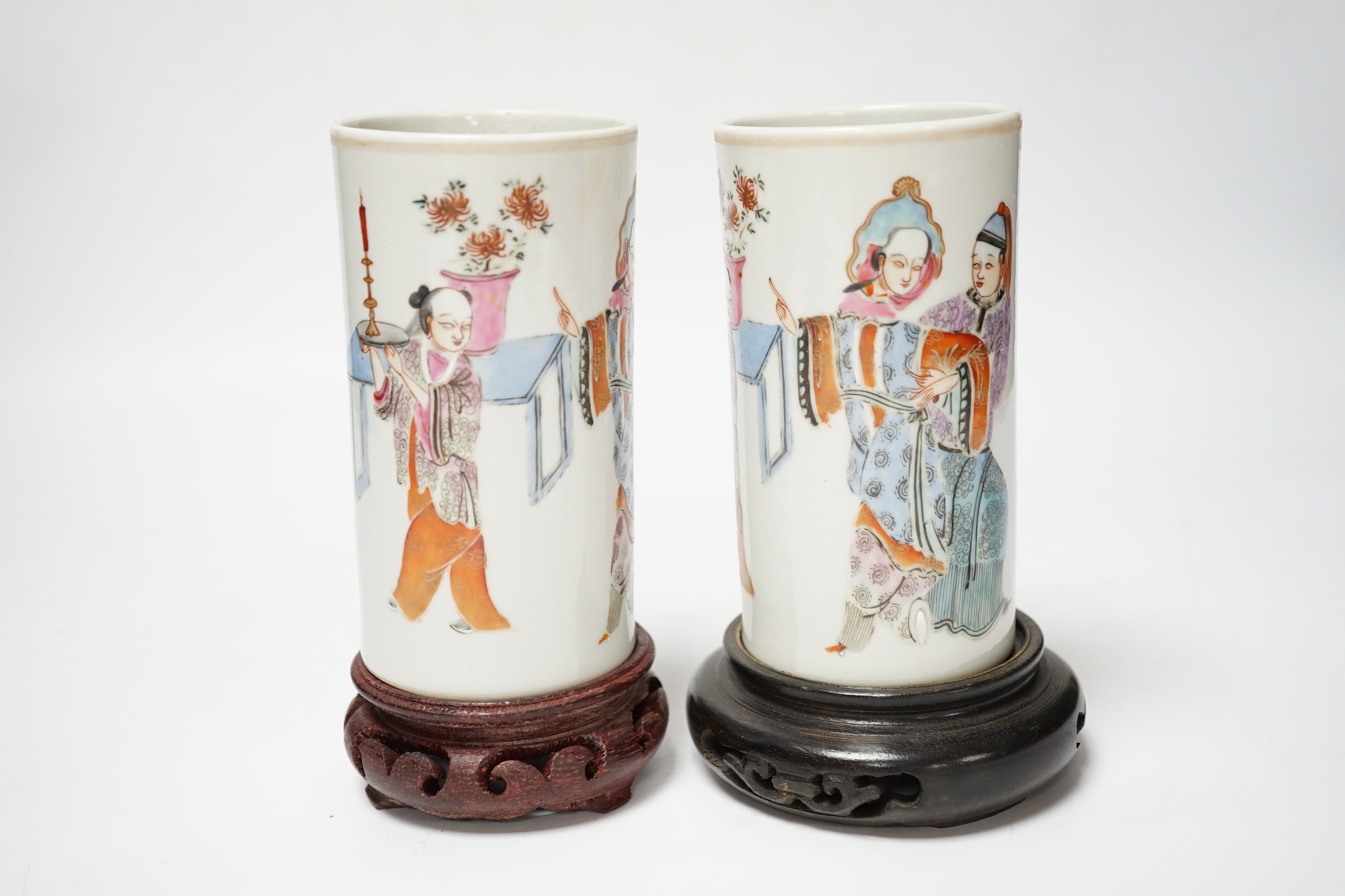 A pair of Chinese cylindrical famille rose brush pots on associated stands, largest 15cm high overall